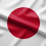 Bandeira do Japão em tecido com dobras suaves, destacando o círculo vermelho central sobre fundo branco — representando o país mais endividado do mundo e seu impacto nas finanças globais, tema abordado no artigo.