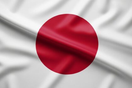 Bandeira do Japão em tecido com dobras suaves, destacando o círculo vermelho central sobre fundo branco — representando o país mais endividado do mundo e seu impacto nas finanças globais, tema abordado no artigo.